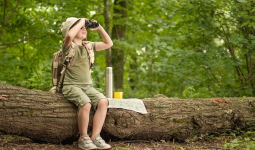 young girl with binoculars in the woods